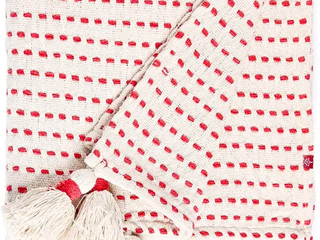 Close up pic of short red dashes on a linen background throw with linen tassels